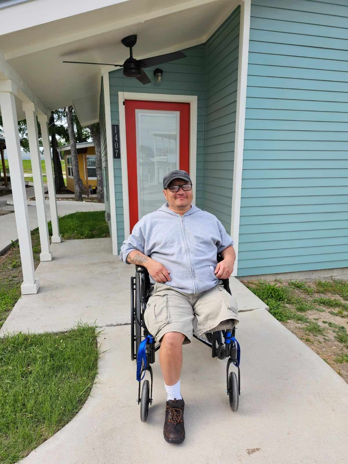 Jae in his wheelchair outside his home